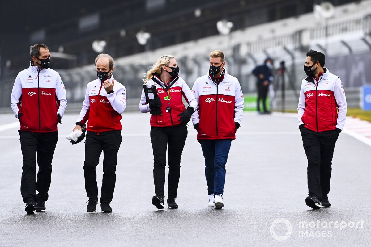 Mick Schumacher, Alfa Romeo, recorre la pista con miembros del equipo
