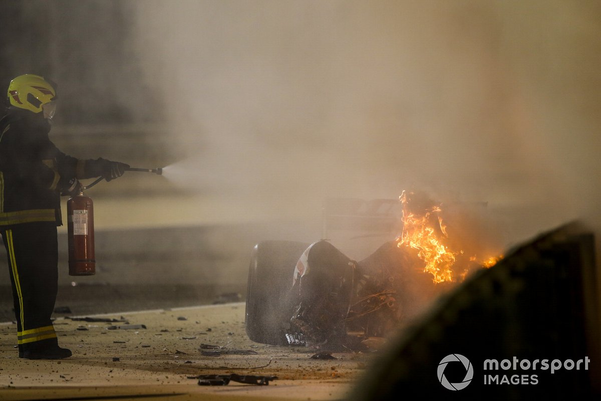 Marshals deal with the wreckage after a huge crash for Romain Grosjean, Haas VF-20, on the opening lap