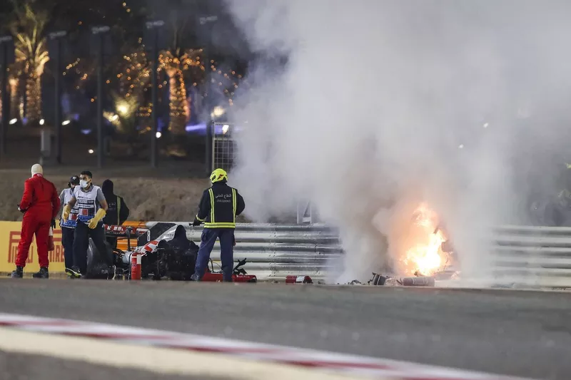 Los oficiales de pista trabajan para apagar el fuego en la escena del accidente