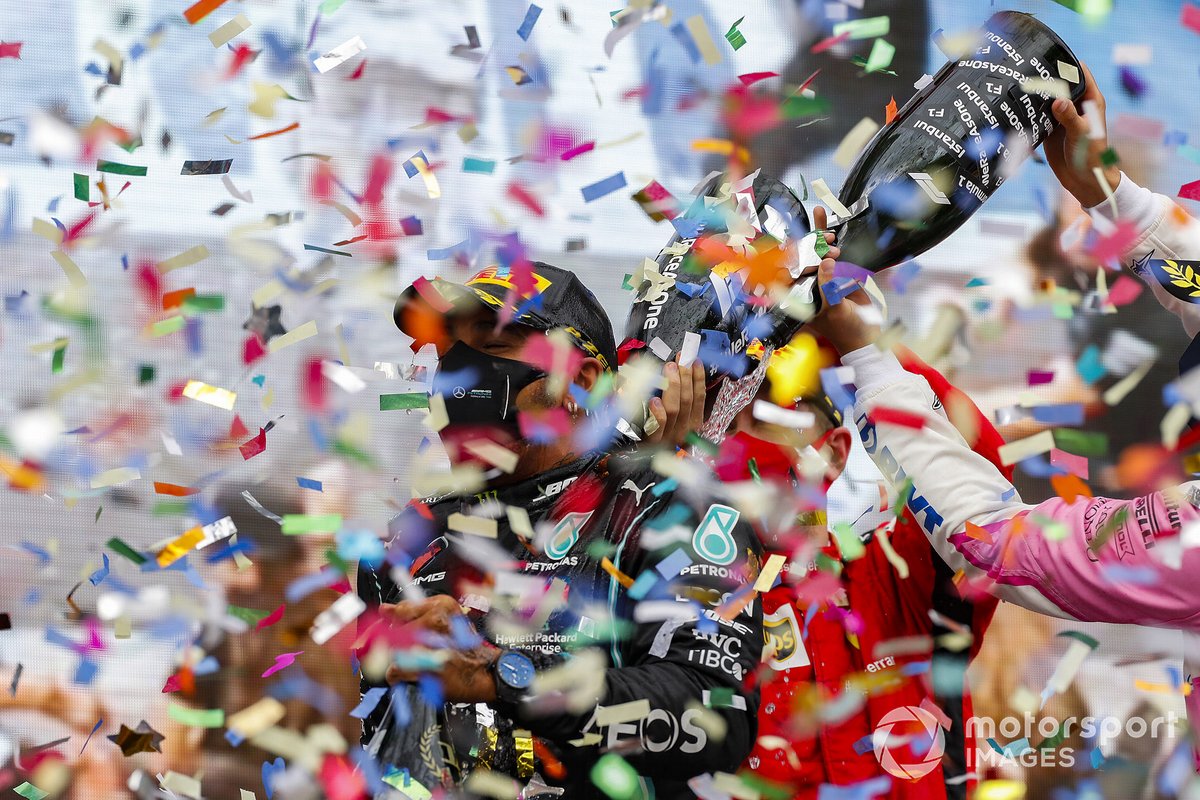 Sebastian Vettel, Ferrari, 3rd position, and Sergio Perez, Racing Point, 2nd position, pour Champagne over Lewis Hamilton, Mercedes-AMG F1, 1st position, on the podium