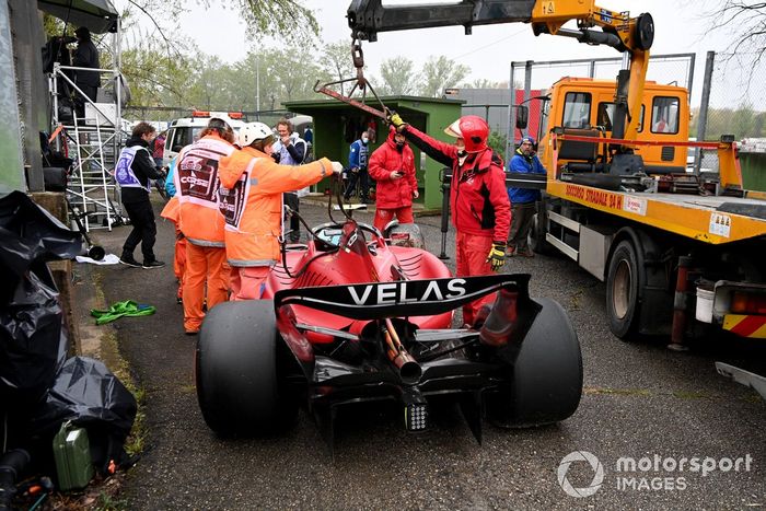 Oficiales de pista cargan el coche de Carlos Sainz Jr., Ferrari F1-75, en una grúa