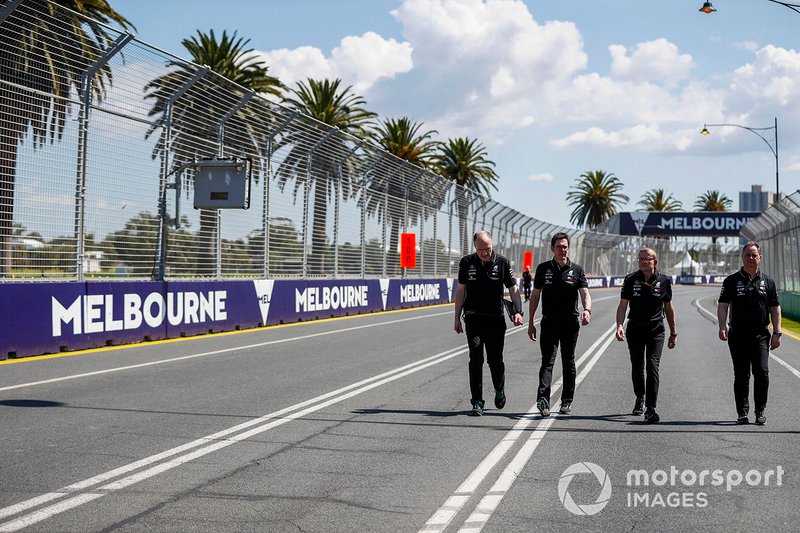 Mercedes team personnel walk the track