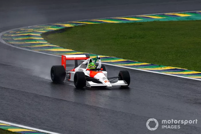 Lewis Hamilton conduce el McLaren MP4/5B mientras sigue la bandera brasileña desde el cockpit