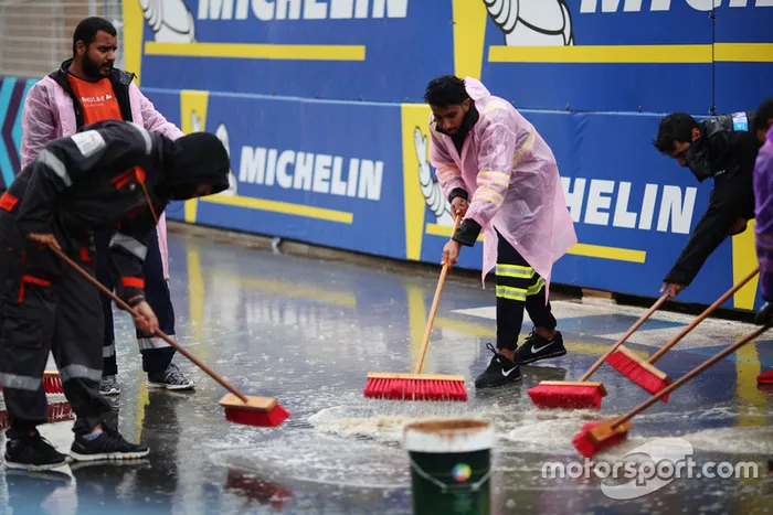 Oficiales tratan de secar la pista