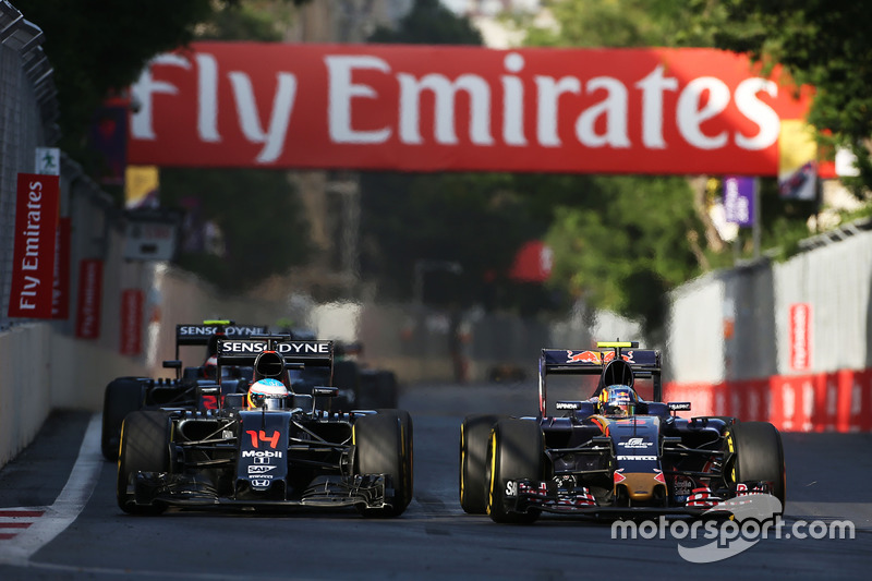 (L to R): Fernando Alonso, McLaren MP4-31 and Carlos Sainz Jr., Scuderia Toro Rosso STR11 battle for position