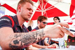 Kevin Magnussen, Haas F1 Team, and Romain Grosjean, Haas F1 Team, sign autographs for fans