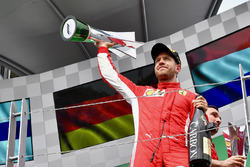 Race winner Sebastian Vettel, Ferrari celebrates with the trophy on the podium