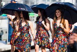 Grid girls shelter from the sun with umbrellas