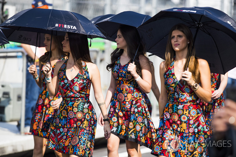 Grid girls shelter from the sun with umbrellas