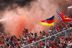 Fans in a grandstand set off flares