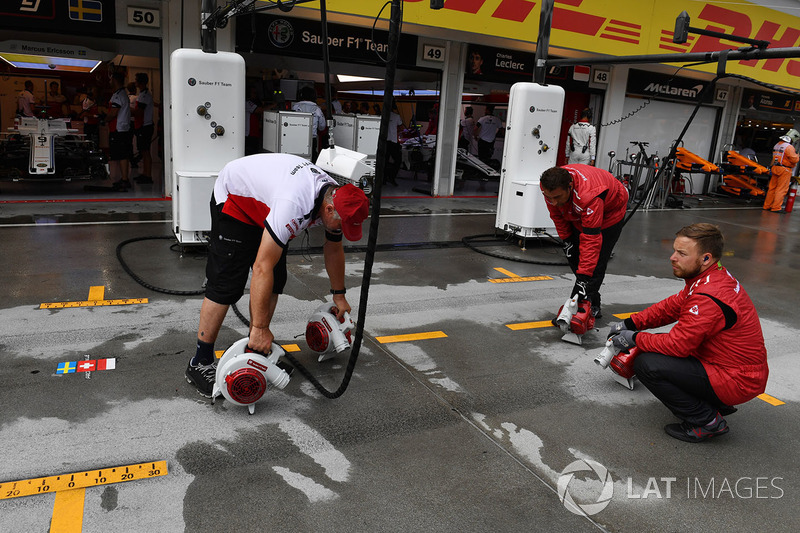 Mecánicos de Sauber secando el suelo