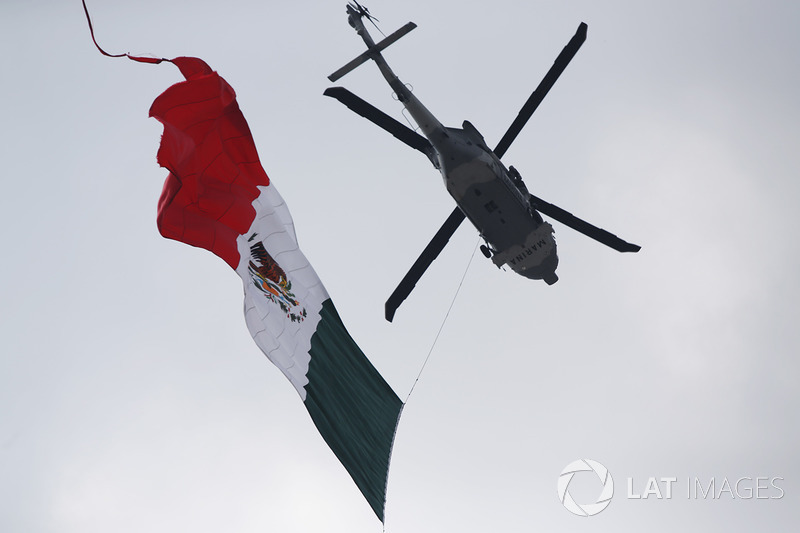 A UH-60M Black Hawk helicopter of the Mexican Navy flies the flag over the grid