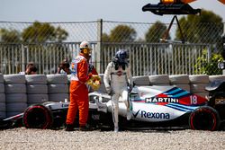 Lance Stroll, Williams FW41, climbs out of his car and is assisted by marshals after spinning into the gravel