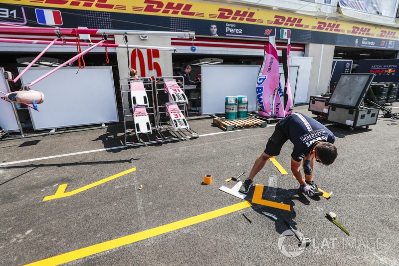 Des membres de Force India travaillent dans la voie des stands