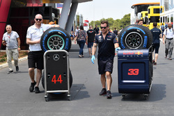 Des mécaniciens Red Bull Racing et Mercedes AMG F1 avec les pneus Pirelli