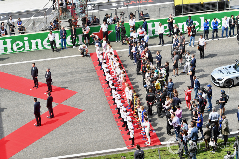Drivers observe the National Anthem on the grid