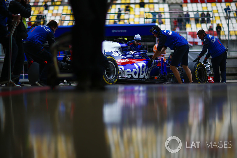 Des mécaniciens Toro Rosso ramènent la voiture de Pierre Gasly, Toro Rosso STR13 Honda, dans le garage