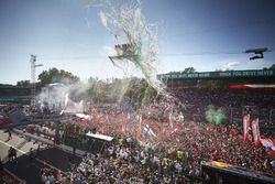 Mercedes team personnel and a huge crowd of Ferrari fans gather for the podium
