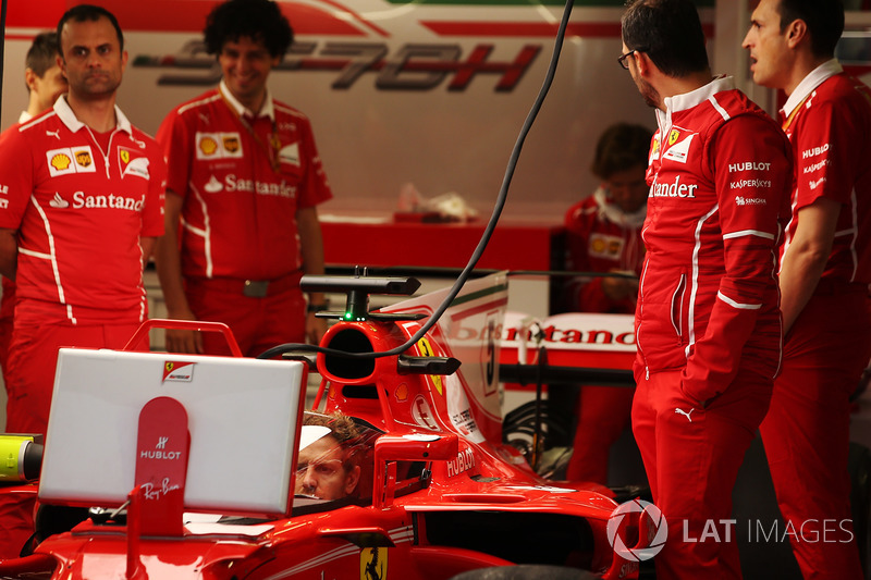 Sebastian Vettel, Ferrari, watches a screen from the cockpit of his car, which is fitted with a new protective windscreen shield