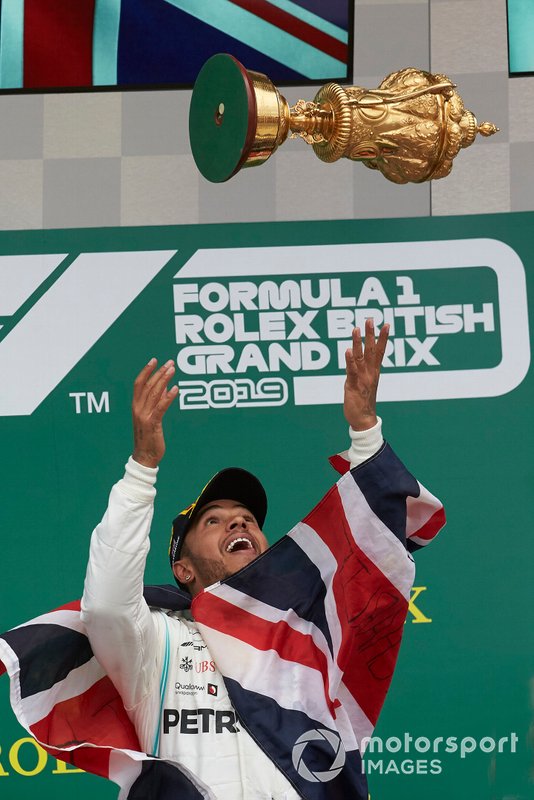 Lewis Hamilton, Mercedes AMG F1, 1st position, tosses his trophy in to their in celebration on the podium
