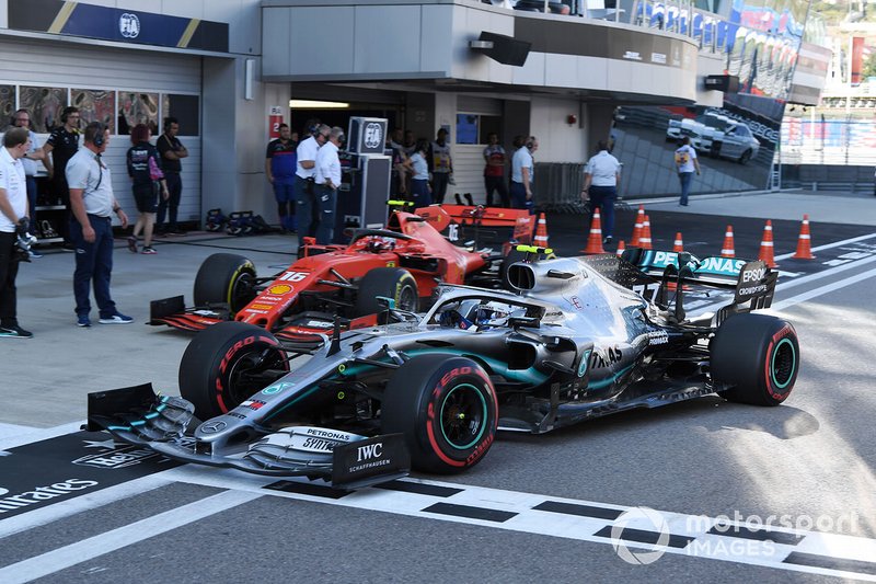 Charles Leclerc, Ferrari SF90, and Valtteri Bottas, Mercedes AMG W10, in the pit lane