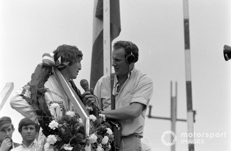 Race winner Jochen Rindt gives an interview on the podium