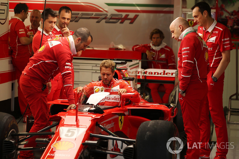 Sebastian Vettel, Ferrari, lowers himself into the cockpit of his car, which is fitted with a new protective windscreen shield