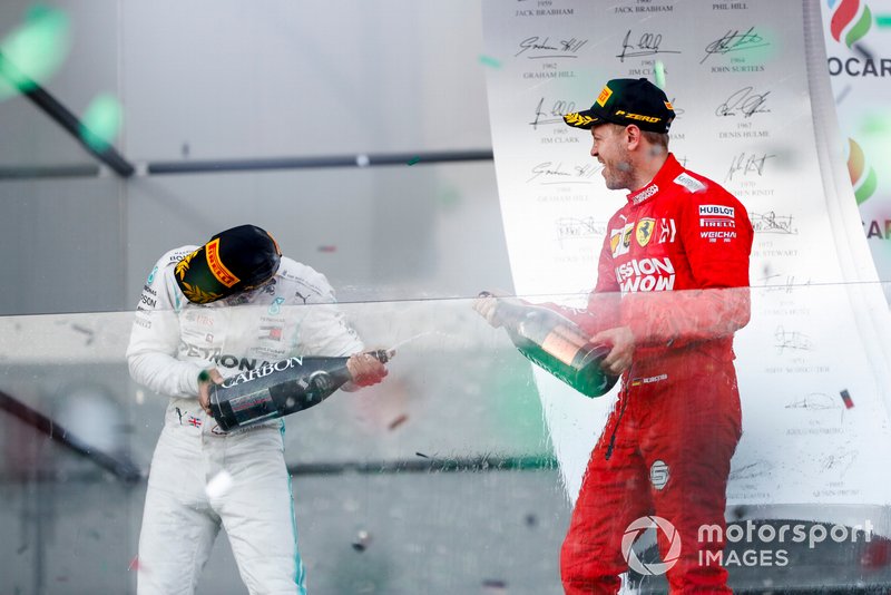 Valtteri Bottas, Mercedes AMG F1, vincitore, e Sebastian Vettel, Ferrari, terzo, festeggiano sul podio con lo champagne