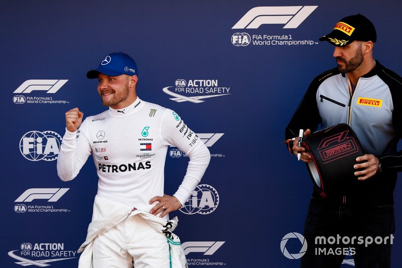 Pole man Valtteri Bottas, Mercedes AMG F1, celebrates as WWE wrestler Cesaro waits to award him his Pirelli Pole Position award