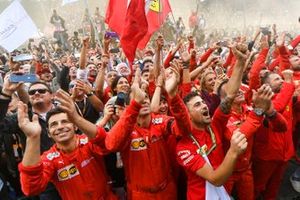 The Ferrari team gather to celebrate victory at the podium