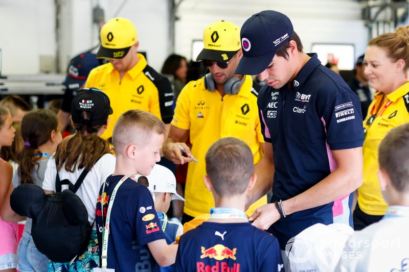 Lance Stroll, Racing Point, Daniel Ricciardo, Renault F1 Team e Nico Hulkenberg, Renault F1 Team firma autografi per i Grid Kids