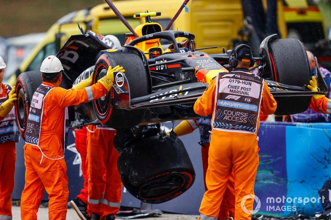 Los comisarios retiran el coche dañado de Sergio Pérez, Red Bull Racing RB20