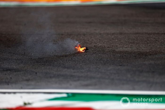 Escombros en llamas del coche de Alex Albon, Williams FW44, en la pista
