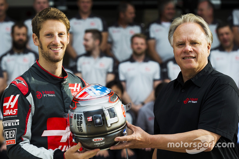 Romain Grosjean presents team owner Gene Haas with his commemorative helmet for the United States Grand Prix