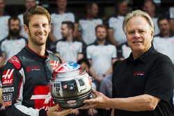 Romain Grosjean presents team owner Gene Haas with his commemorative helmet for the United States Grand Prix