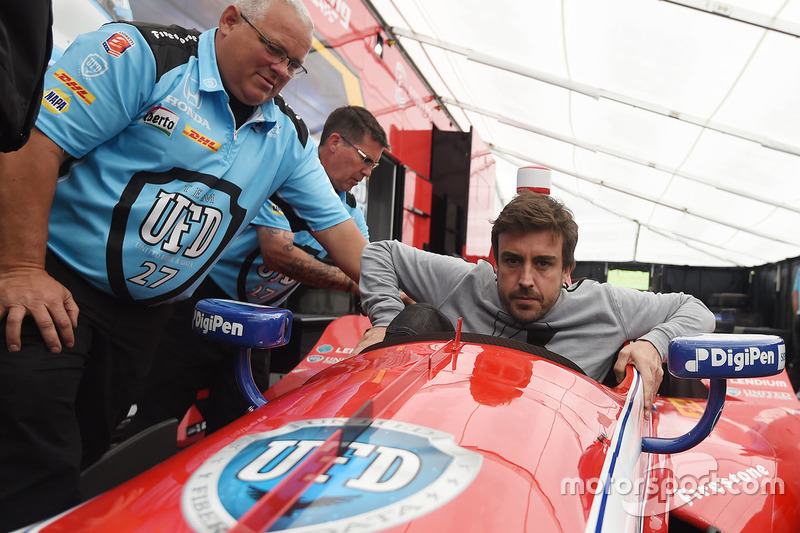 Fernando Alonso sits in the car of Marco Andretti