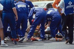 Medical staff tend to Martin Donnelly, Team Lotus, after a horrific crash