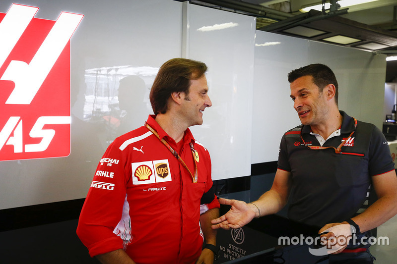 Luigi Frabone, Head of Engine Trackside Operations, Ferrari, parla con un membro del team Haas F1 nel garage