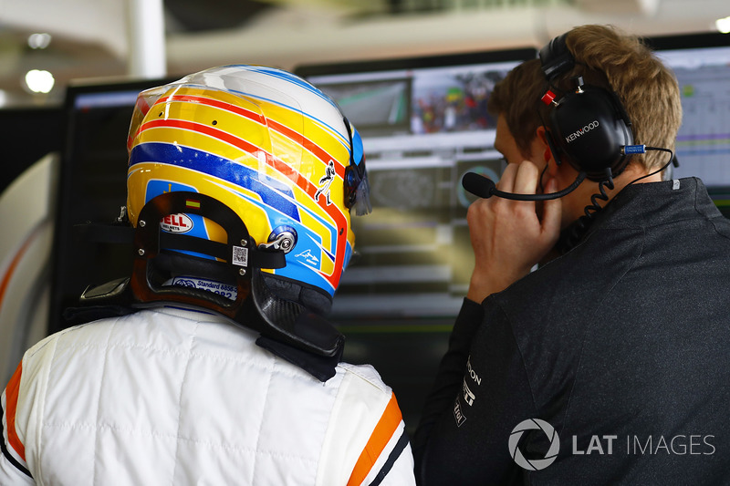 Fernando Alonso, McLaren, talks with his engineer in the garage