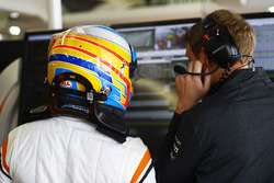 Fernando Alonso, McLaren, talks with his engineer in the garage