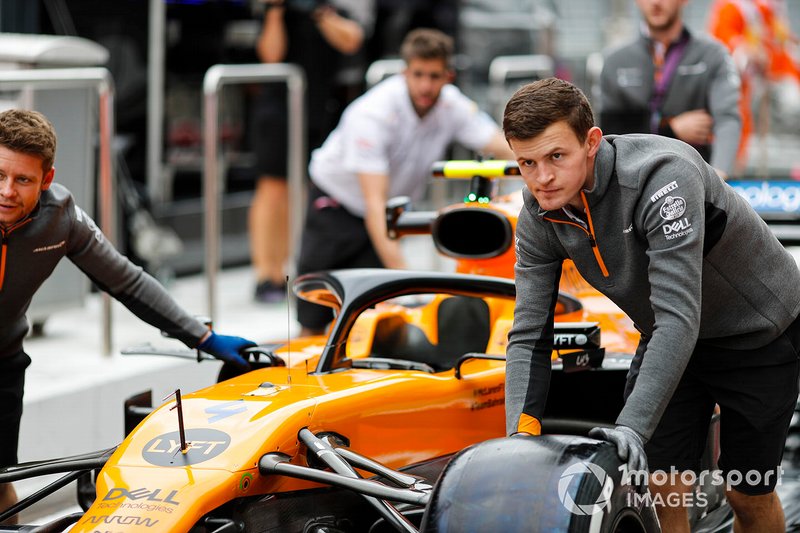Les mécaniciens McLaren poussent la monoplace de Lando Norris