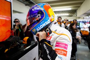 Fernando Alonso, McLaren, adjusts his crash helmet