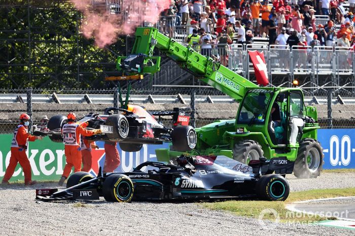 Los oficiales de pista retiran de la grava los coches de Max Verstappen, Red Bull Racing RB16B, y Lewis Hamilton, Mercedes W12