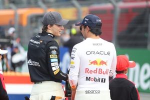 Oscar Piastri, McLaren F1 Team, habla con Sergio Pérez, Red Bull Racing, en la parrilla de salida 
