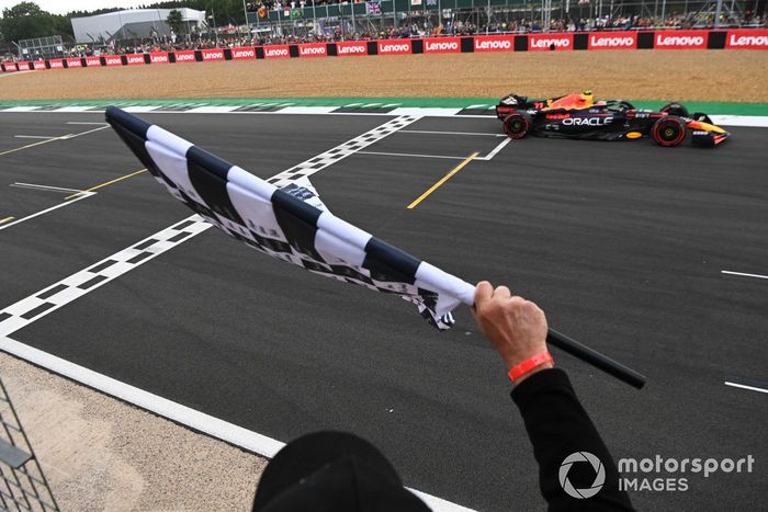 La bandera a cuadros ondea cuando Sergio Pérez, el RB18 de Red Bull Racing, en segunda posición, cruza la línea de meta