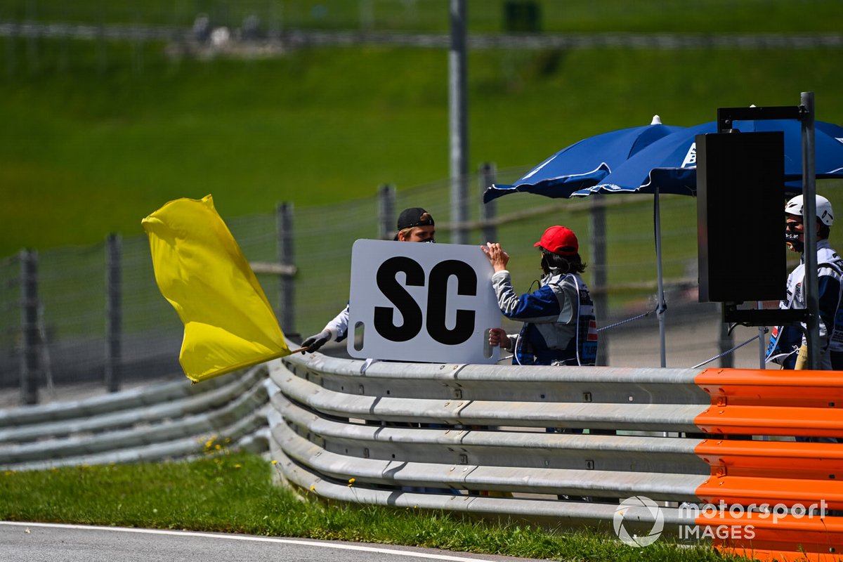 Marshals sventolano la bandiera gialla e mostrano il cartello della safety car