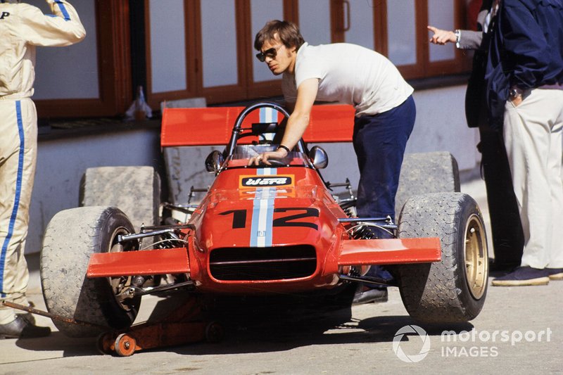 Piers Courage stands beside his De Tomaso 308 Ford in the pit lane
