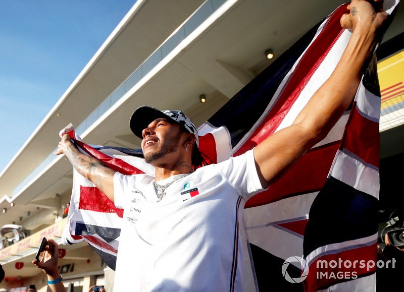 Lewis Hamilton, Mercedes AMG F1, lifts a Union Flag after winning the world championship