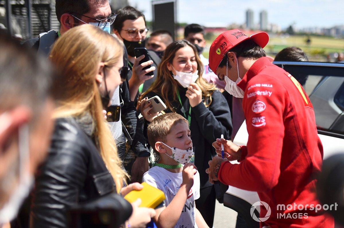 Carlos Sainz Jr., de Ferrari, firma un autógrafo para los jóvenes aficionados