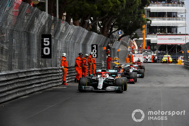 Marshal in pista mentre transitano Lewis Hamilton, Mercedes AMG F1 W10 e Pierre Gasly, Red Bull Racing RB15
